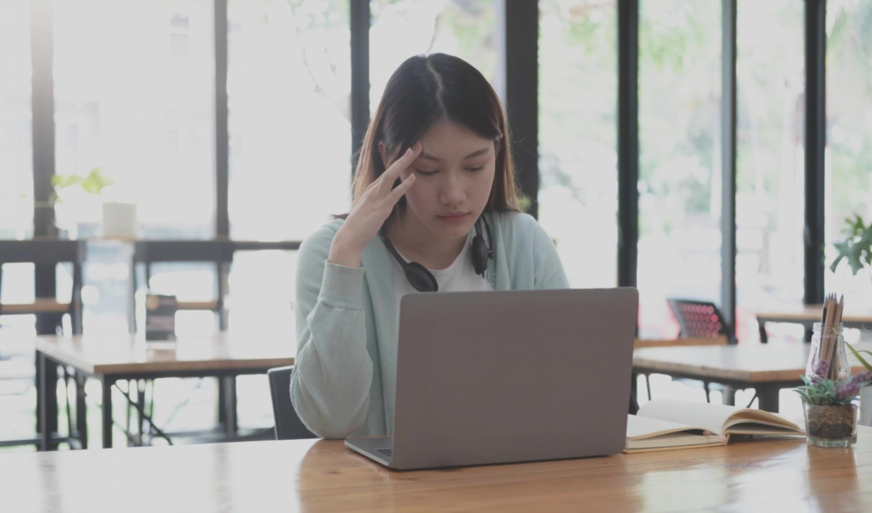 Student reviewing blockchain materials on laptop with focused concentration